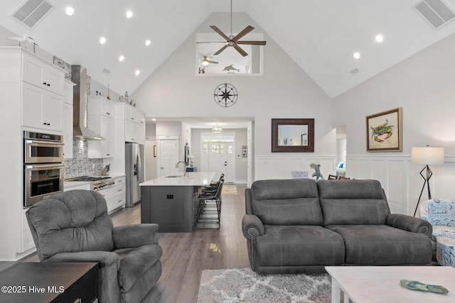 living room with sink, ceiling fan, high vaulted ceiling, and hardwood / wood-style floors