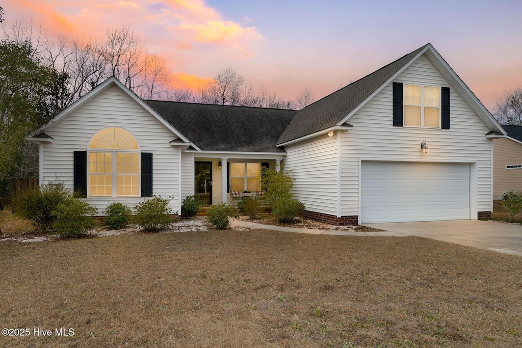 view of property with a lawn and a garage