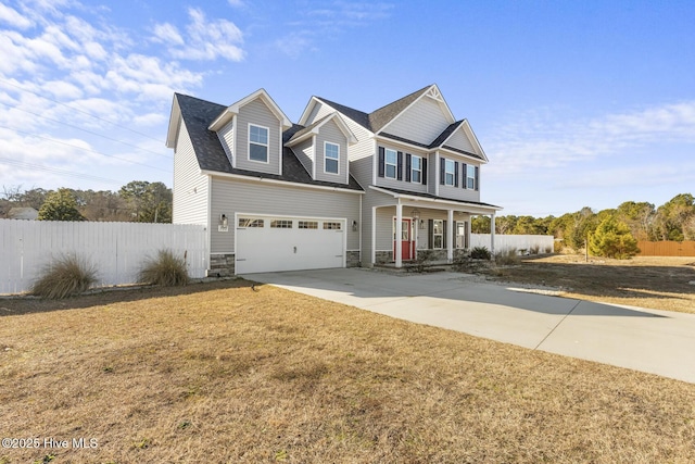 view of front of house with a front yard, covered porch, and a garage