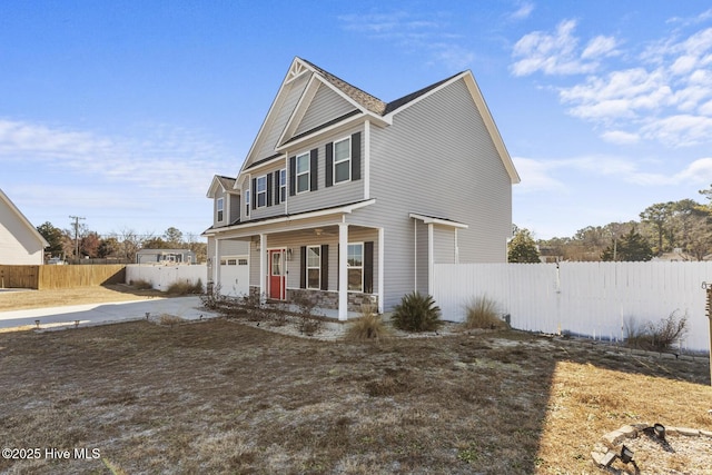 view of property featuring covered porch and a garage