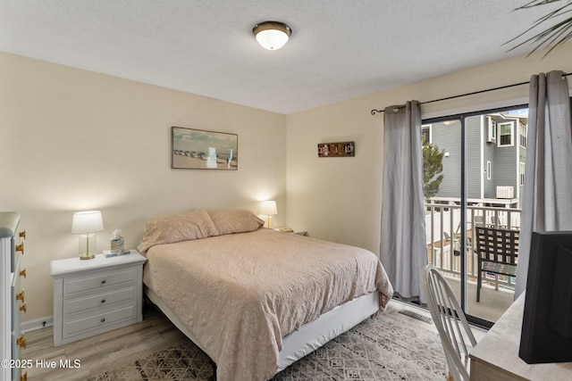 1503 Carolina Beach Ave N Unit 1D, Carolina Beach, NC 28428 - bedroom featuring light wood finished floors, access to exterior, and a textured ceiling