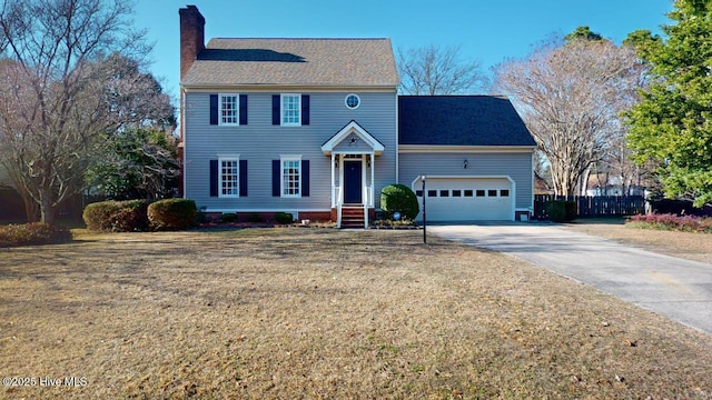 colonial inspired home with a garage and a front lawn