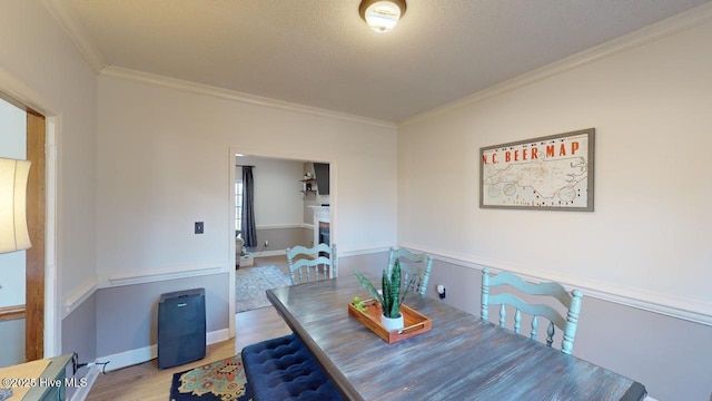 dining room with crown molding, wood-type flooring, and a textured ceiling