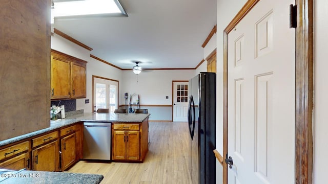 kitchen with black refrigerator, ornamental molding, stainless steel dishwasher, kitchen peninsula, and light hardwood / wood-style flooring