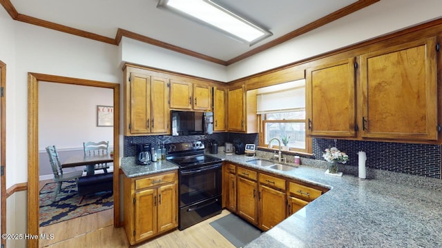 kitchen with tasteful backsplash, ornamental molding, sink, and black appliances