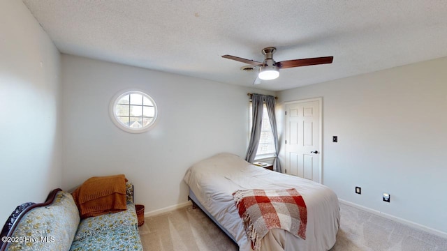 carpeted bedroom with ceiling fan and a textured ceiling