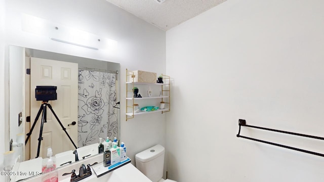 bathroom with a textured ceiling, toilet, and a shower with shower curtain