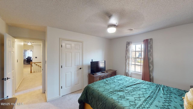 bedroom with light carpet, a textured ceiling, and ceiling fan