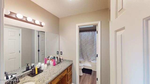 bathroom featuring vanity, toilet, hardwood / wood-style floors, and a textured ceiling
