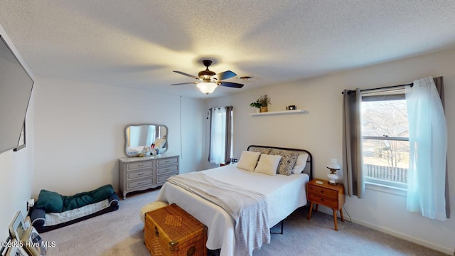carpeted bedroom with ceiling fan and a textured ceiling