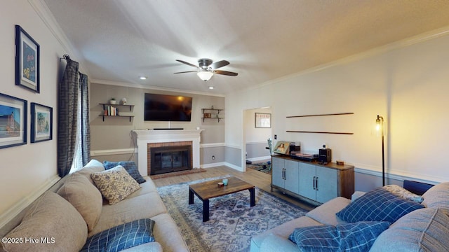 living room with crown molding, ceiling fan, hardwood / wood-style floors, a fireplace, and a textured ceiling
