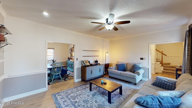 living room featuring crown molding, a textured ceiling, and light hardwood / wood-style floors