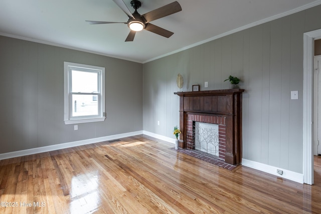 unfurnished living room with a brick fireplace, ceiling fan, crown molding, and light hardwood / wood-style floors