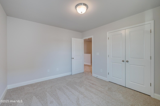 unfurnished bedroom featuring a closet, carpet, and baseboards