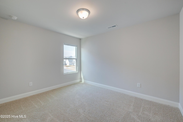 carpeted spare room featuring baseboards and visible vents