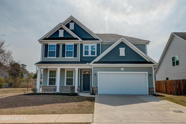 craftsman-style home featuring board and batten siding, concrete driveway, covered porch, and fence