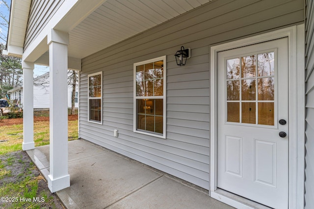 view of exterior entry featuring covered porch