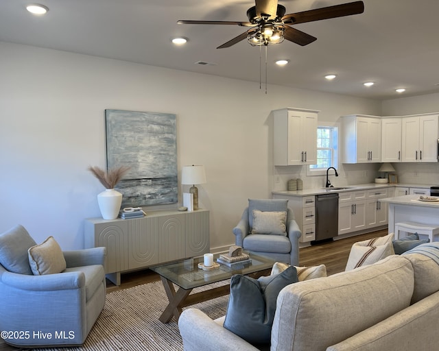 living room featuring ceiling fan, sink, and wood-type flooring