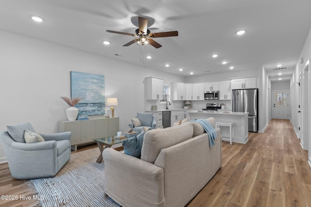 kitchen featuring appliances with stainless steel finishes, light countertops, a kitchen island, and white cabinetry