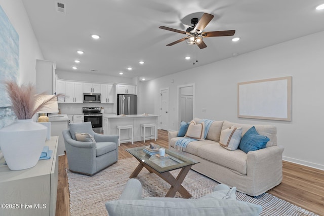 living room featuring dark wood-type flooring, recessed lighting, and baseboards