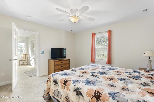 living area featuring light carpet and ceiling fan