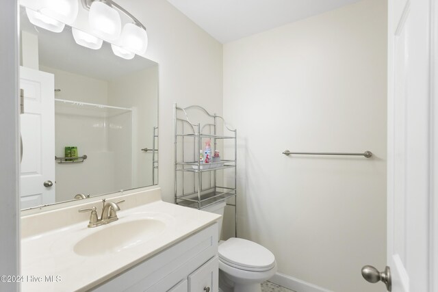 bedroom with ceiling fan, light colored carpet, and ensuite bath