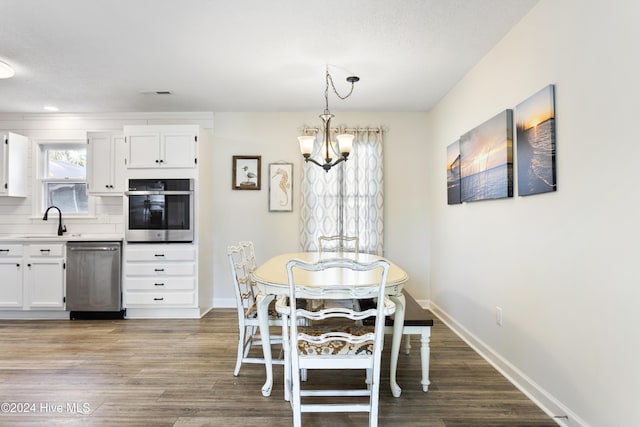 dining room featuring hardwood / wood-style floors, a notable chandelier, and sink