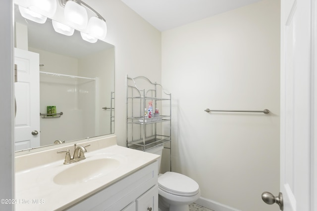 bathroom featuring toilet, vanity, and walk in shower