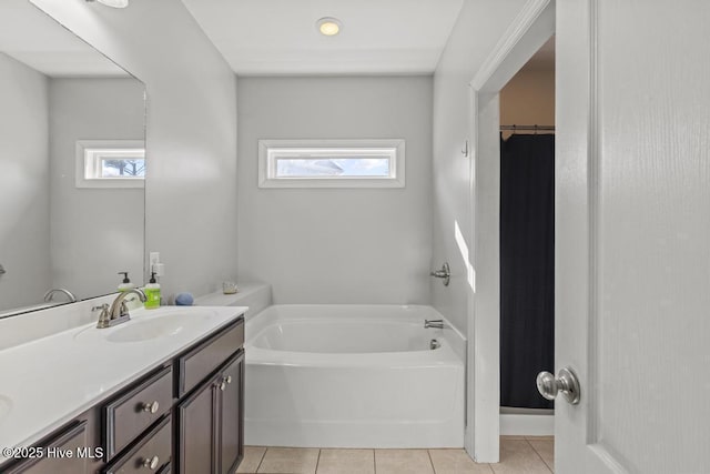 bathroom featuring a washtub, tile patterned floors, vanity, and a healthy amount of sunlight