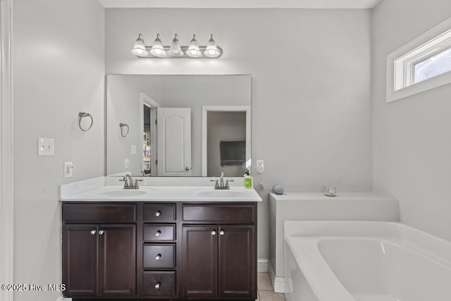 bathroom featuring tile patterned flooring, a washtub, and vanity