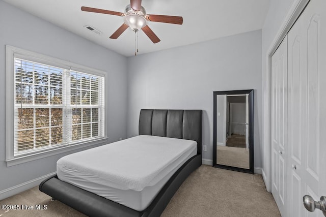 carpeted bedroom with ceiling fan and a closet