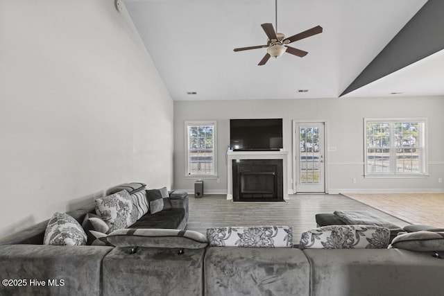 living room featuring ceiling fan, vaulted ceiling, a wealth of natural light, and hardwood / wood-style flooring