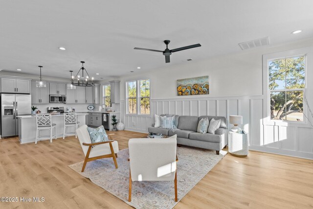 kitchen featuring sink, gray cabinetry, hanging light fixtures, a kitchen breakfast bar, and stainless steel appliances