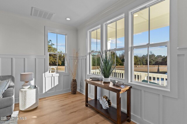 living room featuring crown molding, light hardwood / wood-style floors, and ceiling fan