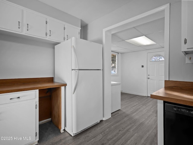 kitchen featuring white cabinetry, white fridge, black dishwasher, and hardwood / wood-style floors