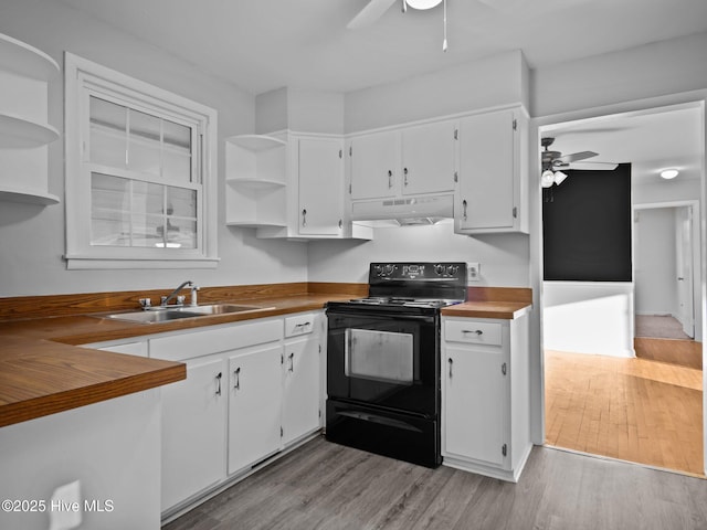 kitchen with sink, butcher block counters, black range with electric cooktop, and white cabinets