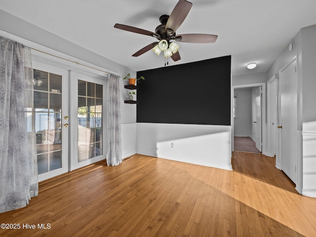 spare room featuring hardwood / wood-style floors, ceiling fan, and french doors