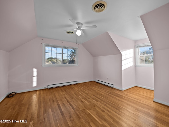 bonus room with a baseboard radiator, vaulted ceiling, and light hardwood / wood-style flooring