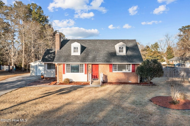 new england style home featuring a garage, an outdoor structure, and a front lawn