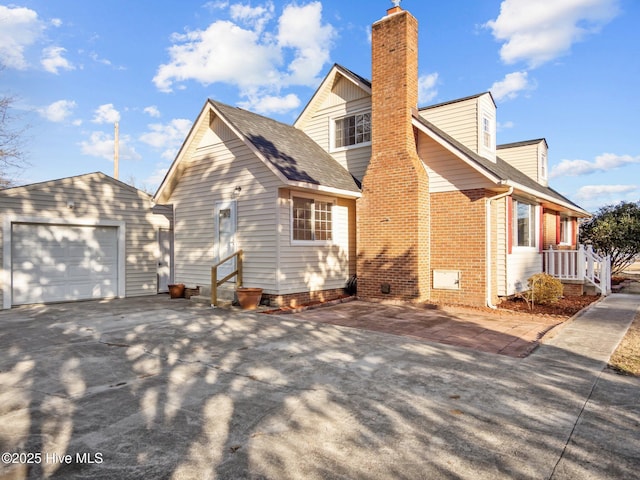 view of side of home featuring a garage and an outdoor structure