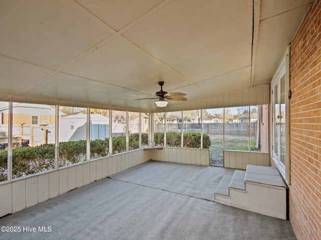 unfurnished sunroom featuring ceiling fan