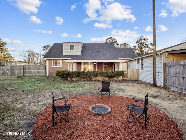 rear view of property featuring an outdoor fire pit