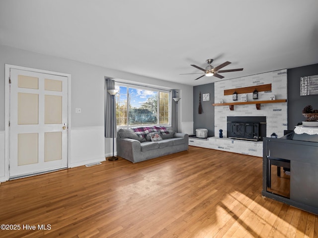 unfurnished living room featuring ceiling fan, a fireplace, and hardwood / wood-style floors