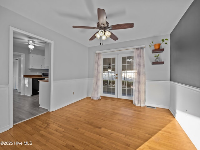 unfurnished room featuring french doors, ceiling fan, and light hardwood / wood-style flooring