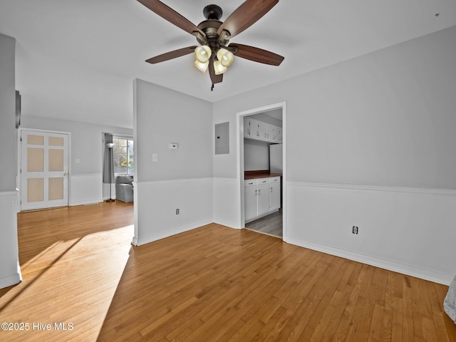 unfurnished living room with electric panel, ceiling fan, and light wood-type flooring