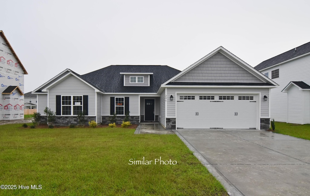 craftsman house featuring a front lawn and a garage