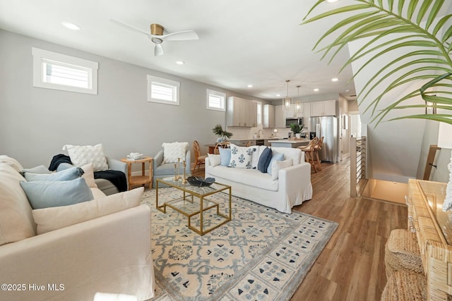 living room featuring ceiling fan and light wood-type flooring