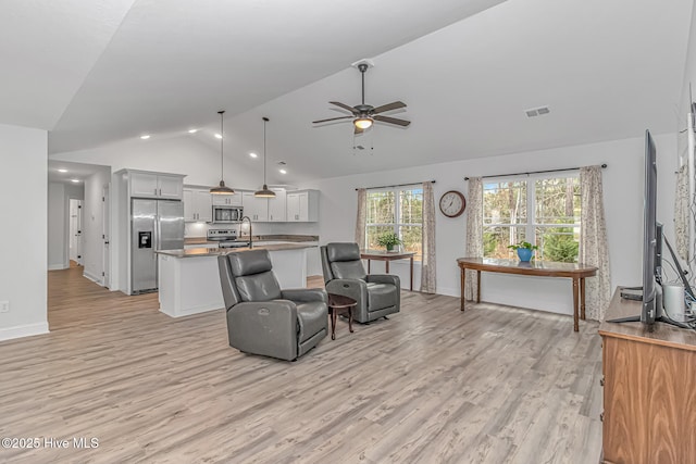 living room featuring lofted ceiling, sink, ceiling fan, and light hardwood / wood-style flooring