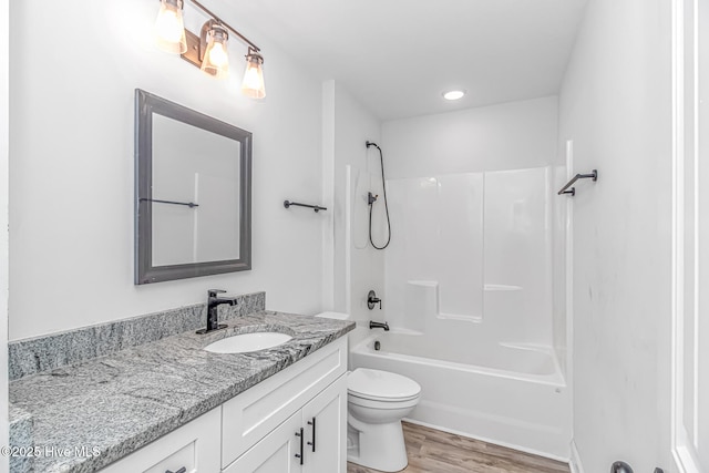 full bathroom with hardwood / wood-style flooring, vanity, toilet, and shower / bathing tub combination