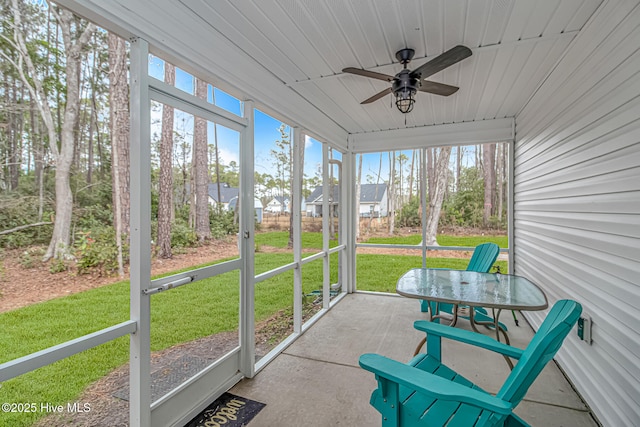 unfurnished sunroom featuring wood ceiling and ceiling fan